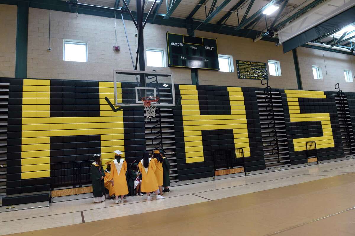Hamden High School graduates wait inside the school's gymnasium before commencement exercises on June 22, 2022.