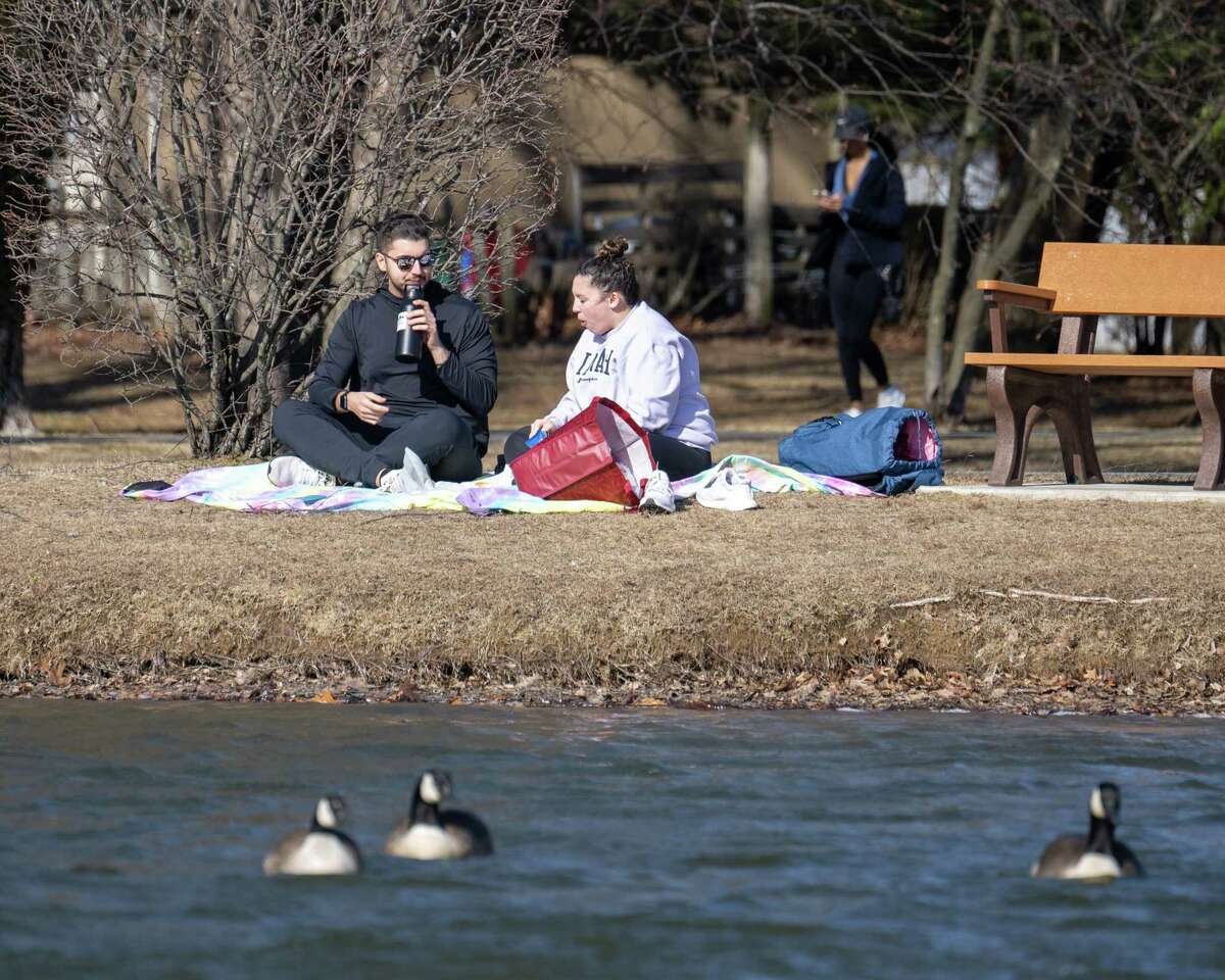 Nick Waugh and Kim Bourgeois take advantage of the warm weather to have a picnic on Wednesday, Feb. 15, 2023, at The Crossings in Colonie, NY.