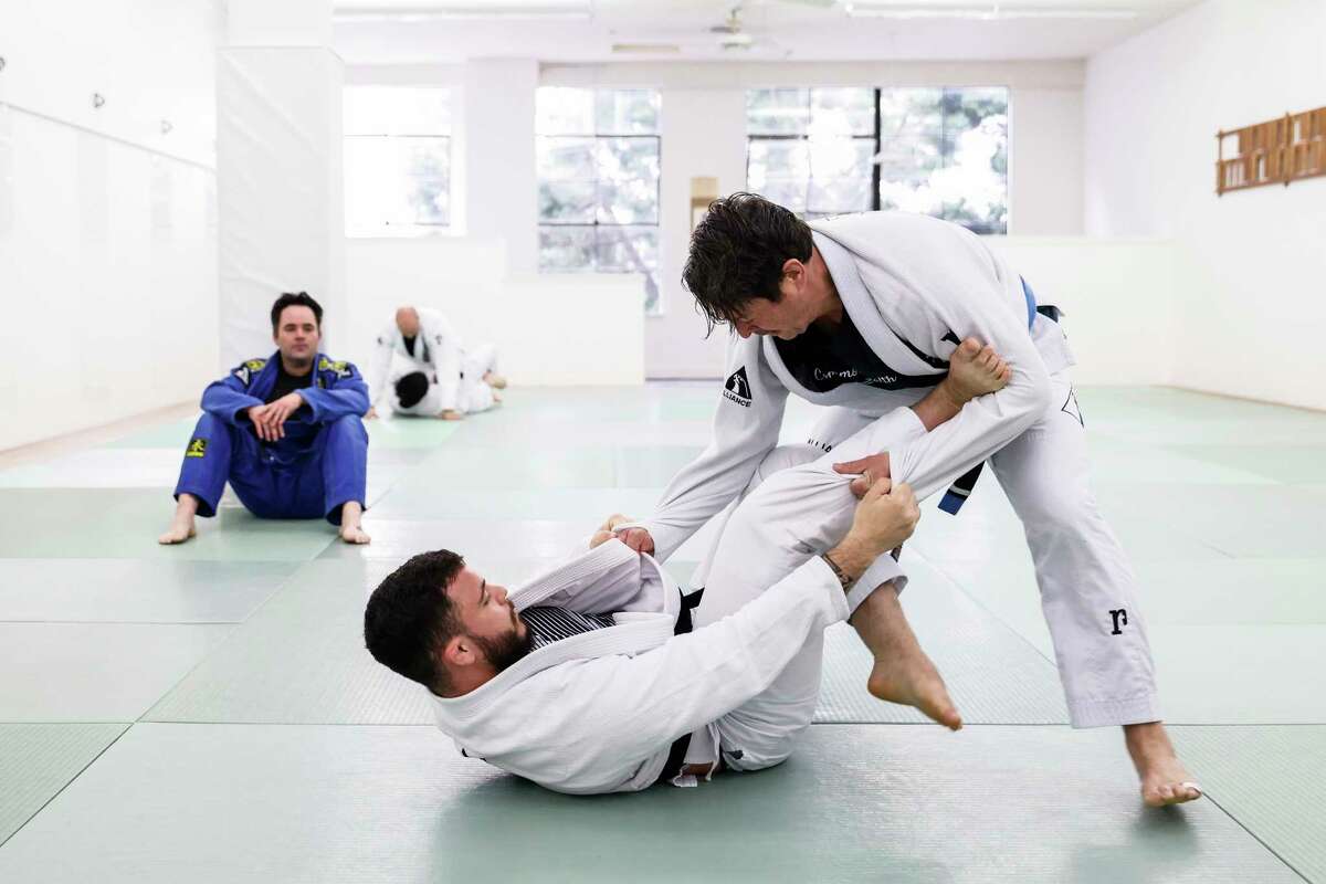 Chef Jason Fox, right, spars with instructor Victor Olivera while his friend and fellow chef Ian Gordon watches during an advanced class at Alliance Jiu-Jitsu in San Francisco, Calif. Thursday, Feb. 2, 2023. Brazilian jiu-jitsu has become increasingly popular with chefs in the Bay Area and beyond. 
