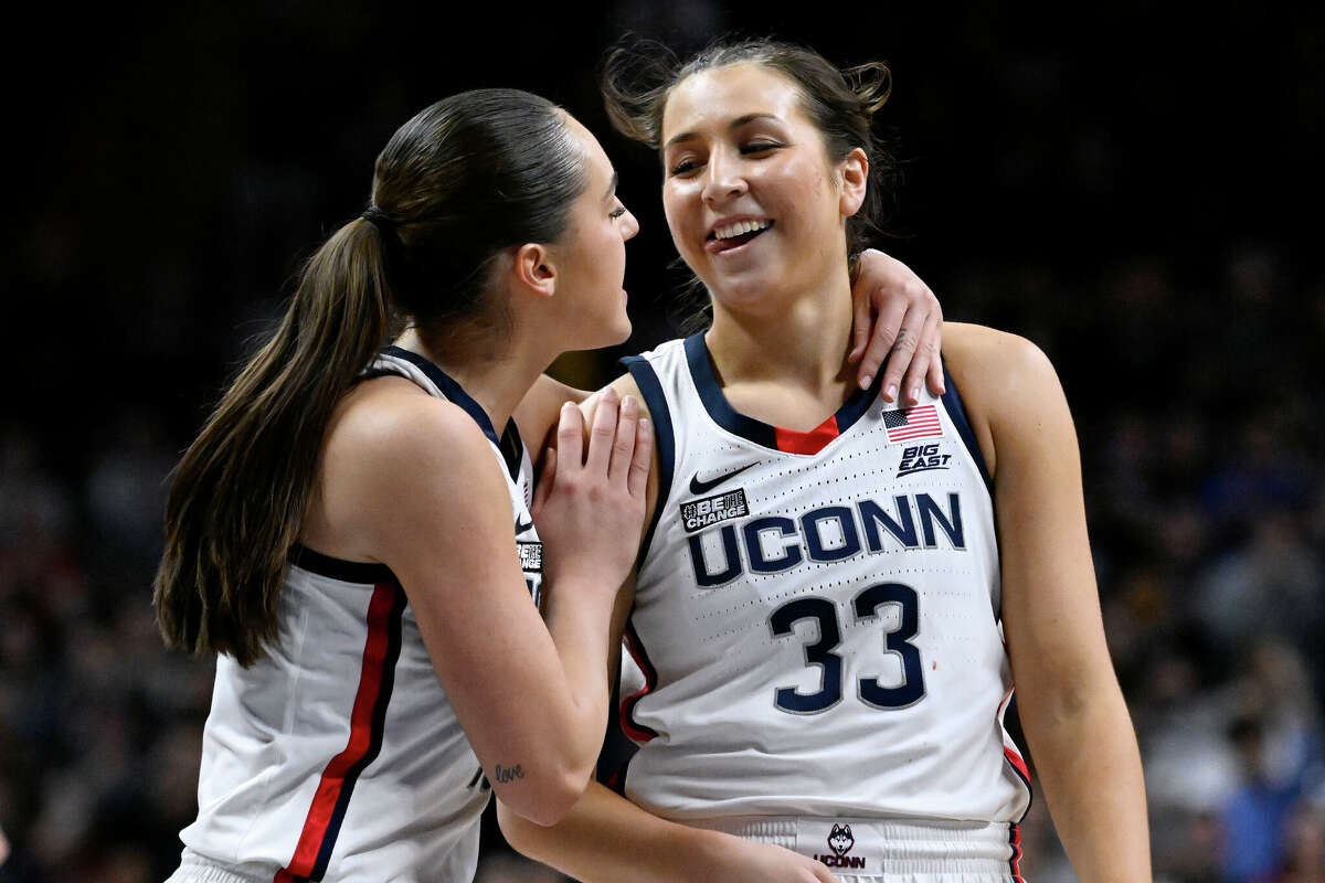UConn's Nika Muhl, left, congratulates Caroline Ducharme (33), who made the go-ahead basket in the final seconds of the team's NCAA college basketball game against Creighton, Wednesday, Feb. 15, 2023, in Storrs, Conn. (AP Photo/Jessica Hill)