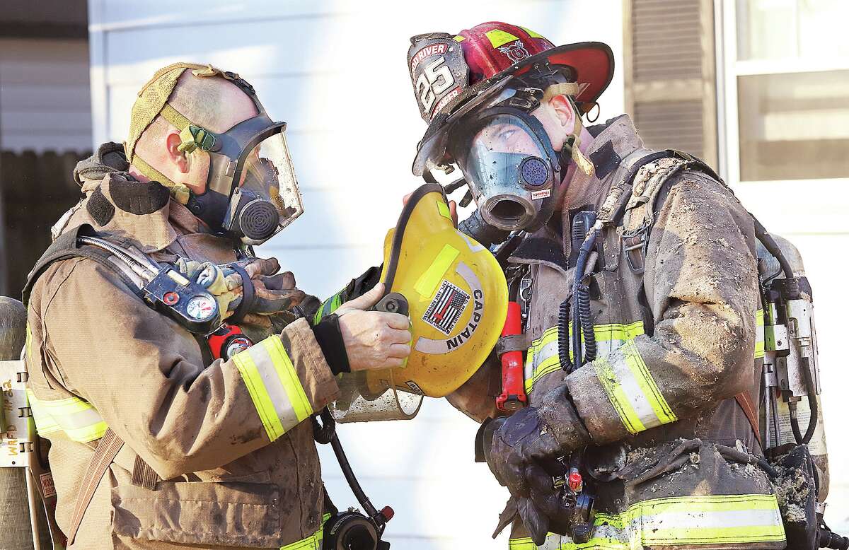 John Badman|The Telegraph Firefighters came out of an attic fire Monday in the 300 block of Washington Street in East Alton covered with insulation.