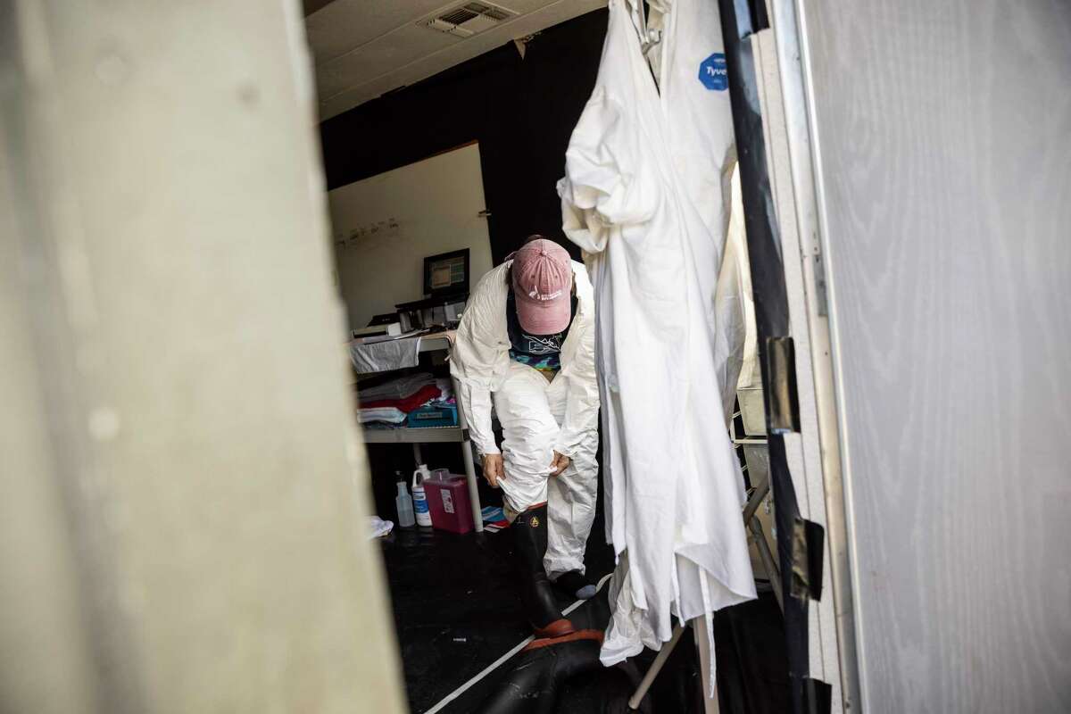 Eli Gordon, a wildlife rehabilitation technician at International Bird Rescue, dons personal protective equipment as he prepares to triage incoming birds in a makeshift quarantine facility due to the ongoing avian influenza outbreak that targets wild birds, in Fairfield, California Wednesday, Dec. 14, 2022.