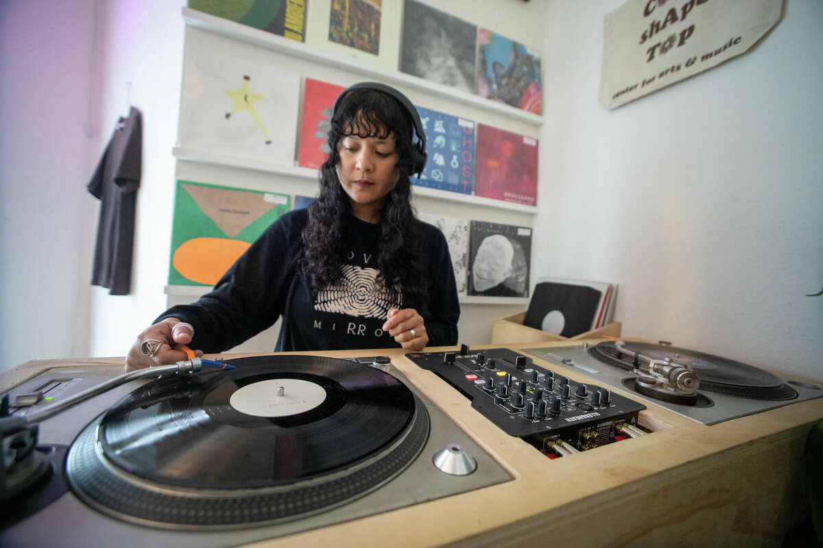 Cat Lauigan mixes some records at a vinyl dj mixing station at Cone Shape Top record store in Oakland, Calif. on Feb. 14, 2023.