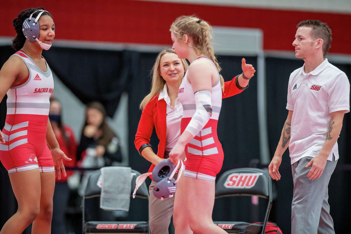 Sacred Heart University womenâs wrestling coach Paulina Biega congratulates Madison Sandquist after a match.