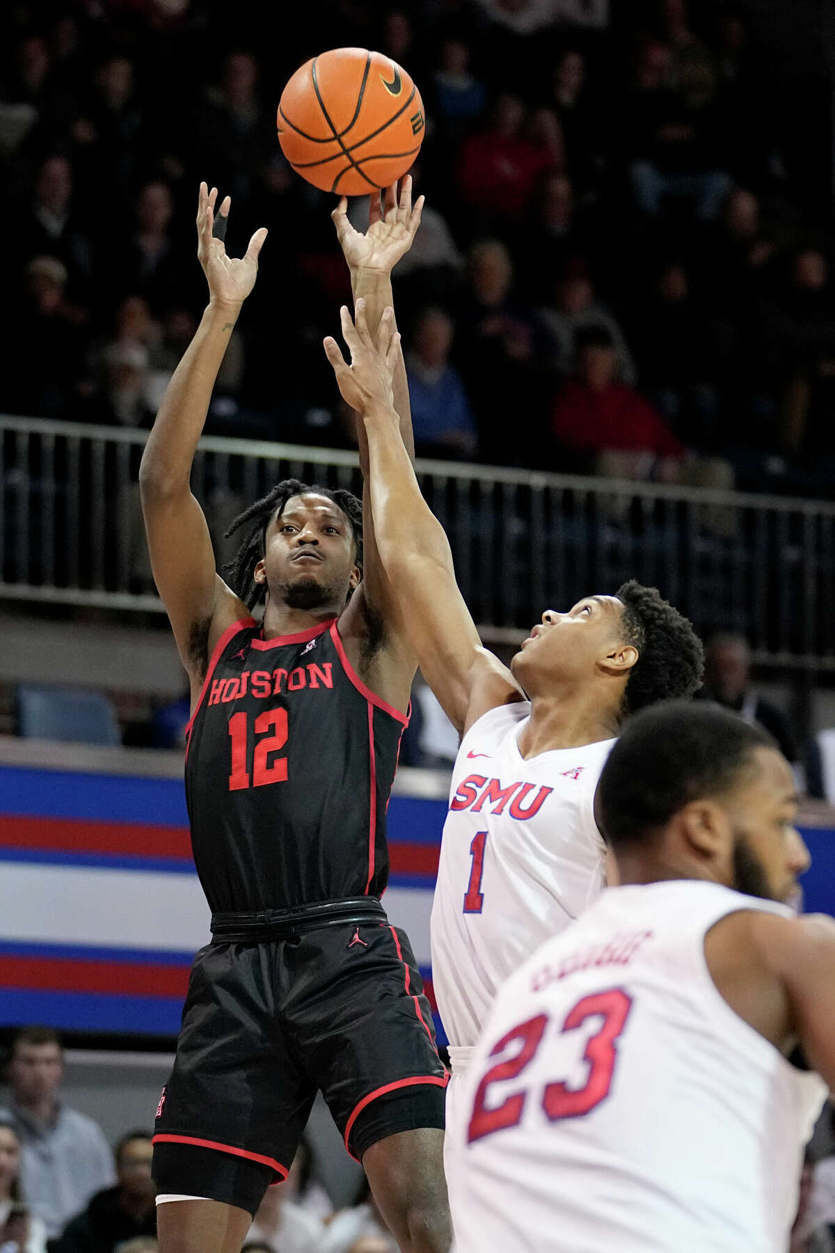 Houston's Tramon Mark (12) shoots over SMU's Zhuric Phelps (1) and Efe Odigie (23) during the first half of an NCAA college basketball game Thursday, Feb. 16, 2023, in Dallas. (AP Photo/Tony Gutierrez)