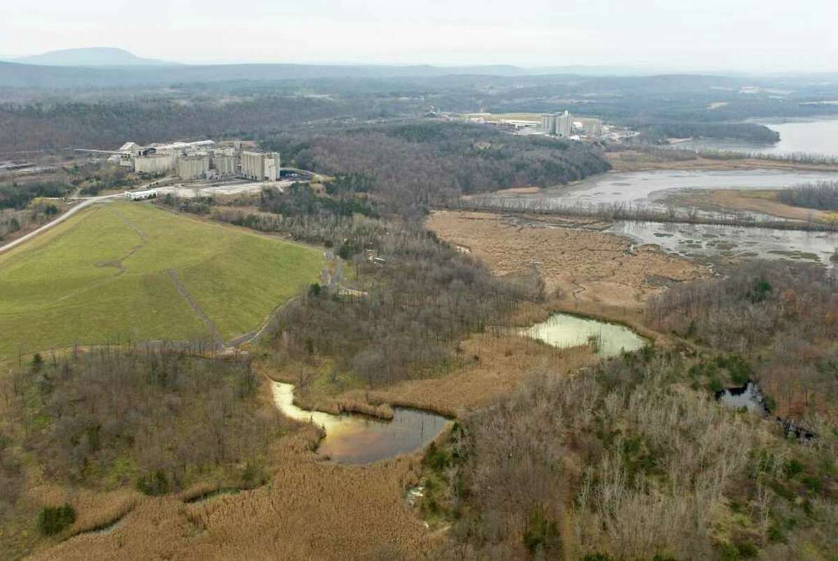 This 2006 aerial photograph taken by the environmental group Riverkeeper shows pollution leaking into Hudson River wetlands from a cement dust dump at the Lehigh cement plant in the Catskills. The wetlands had taken on an orange tint from a blend of chemicals, and was as alkaline as household bleach. (Photo courtesy of Giles Ashford / Riverkeeper)