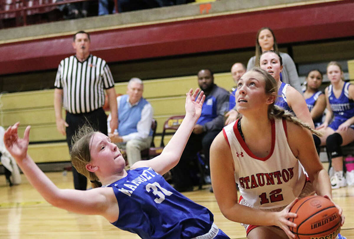 Staunton's Haris Legendre (right) looks to the basket while picking up block foul on Marquette's Allie Weiner in the first half Thursday in the title game of the EA-WR Class 2A Regional in Wood River.