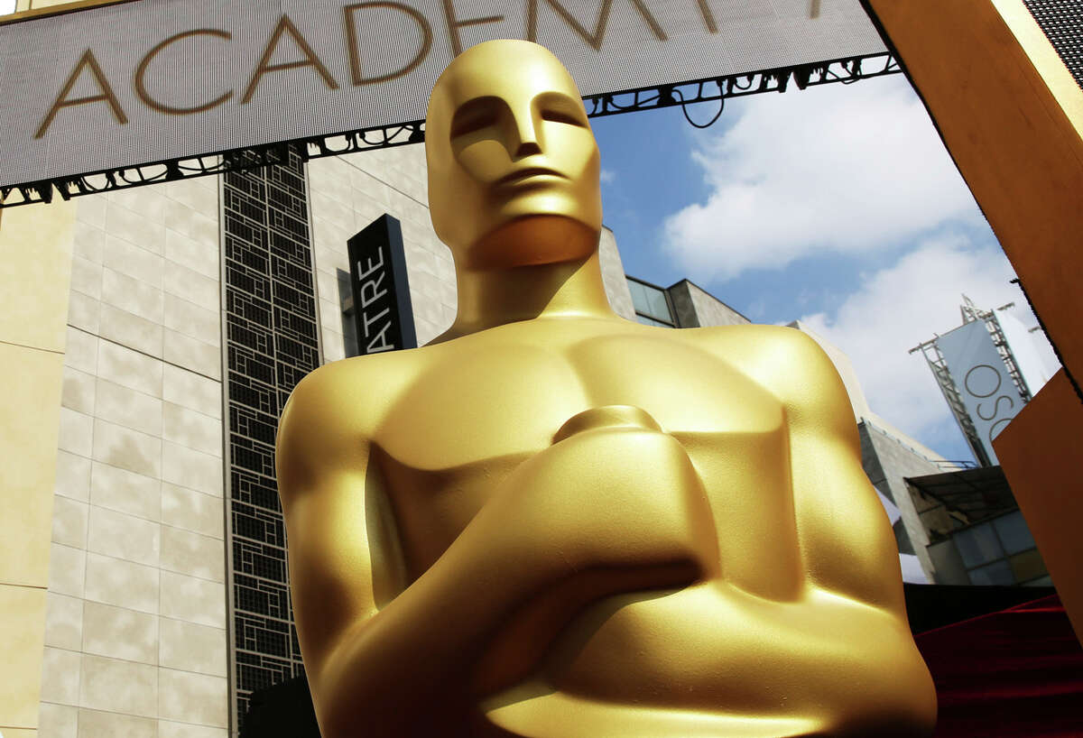 FILE - In this Feb. 21, 2015 file photo, an Oscar statue appears outside the Dolby Theatre for the 87th Academy Awards in Los Angeles. This year's Oscars will be held Sunday, March 12. The ceremony is set to begin at 8 p.m. EST and be broadcast live on ABC. Jimmy Kimmel will host for the third time and his first time since 2018. (Photo by Matt Sayles/Invision/AP, File)