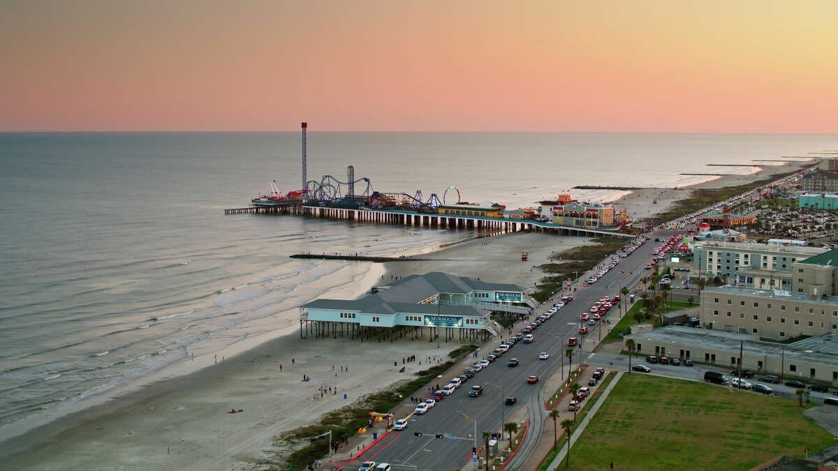 Aerial shot of the historic pier and the beach in Galveston, Texas, at sunset. 