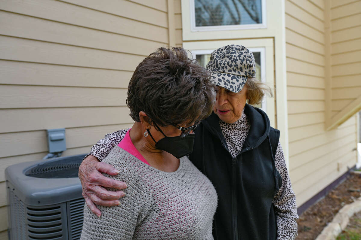 Retired nurse Annie Spradley is moved to tears when she describes the damage done to her yard by the many feral cats that roam her Timber Ridge neighborhood. Here she is comforted by her neighbor Barbara Bir.
