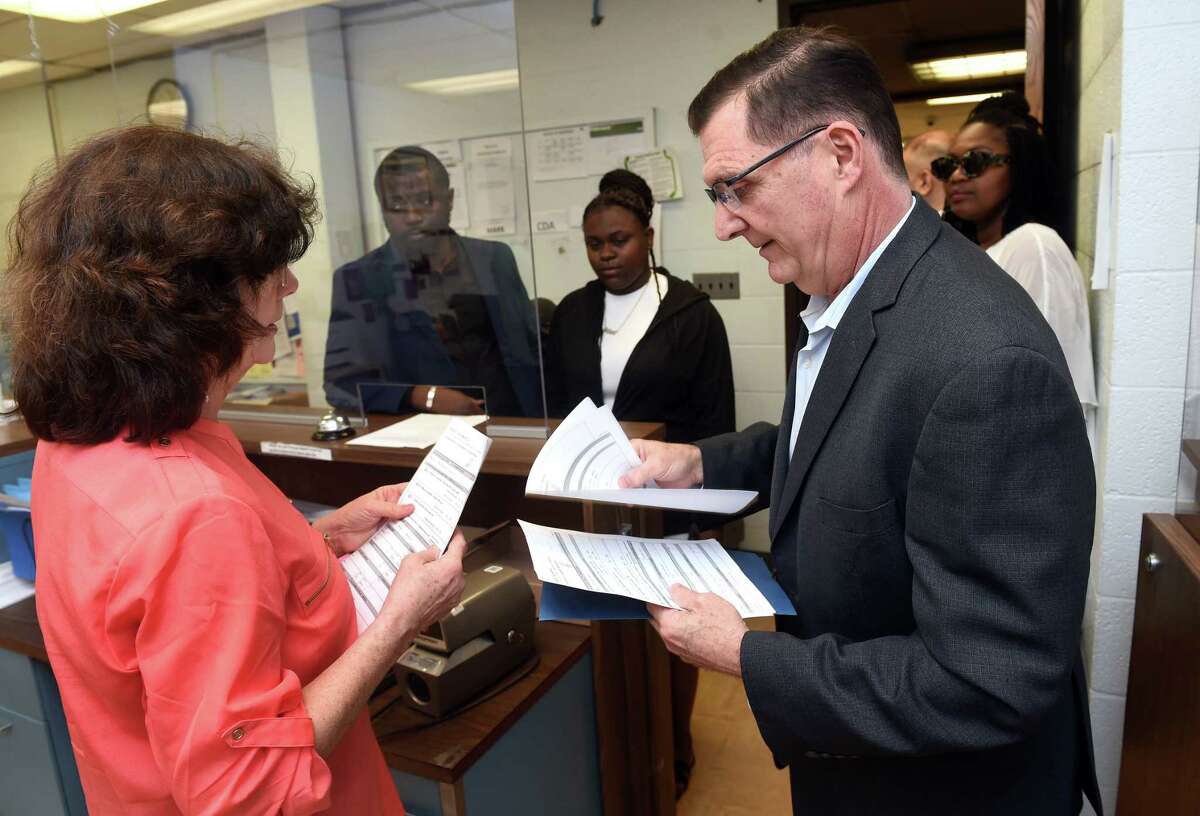 Former West Haven Mayor Ed O'Brien, right, files paperwork for an exploratory committee to run for mayor with City Clerk Patty Horvath in the City Clerk's Office at West Haven City Hall Friday.