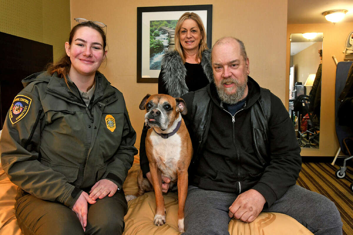 Martin Lillis and his dog Roxie in the motel room where they are currently living, photographed with East Haven Animal Control Office Emily Higgins, left, and Jean Gagliardi. Higgins and Gagliardi are helping to raise funds for Lillis and Roxie, who until recently were living in a car with a broken heater.