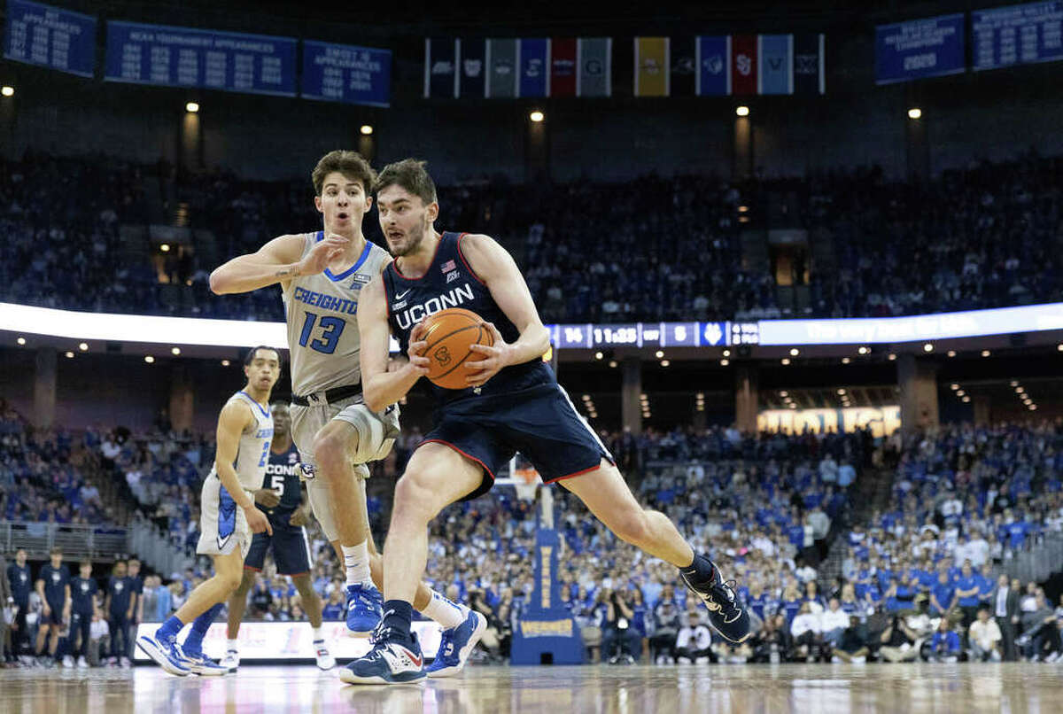 UConn's Alex Karaban, right, drives against Creighton's Mason Miller during the first half of an NCAA college basketball game on Saturday, Feb. 11, 2023, in Omaha, Neb. (AP Photo/Rebecca S. Gratz)
