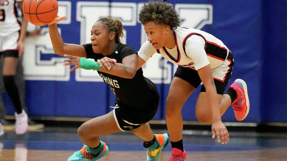 Spring guard Rikeyah Gant, left, reaches for a loose ball as Langham Creek guard Heather Baymon defends during the second half of a Region III-6A area high school basketball playoff game, Friday, Feb. 17, 2023, in Houston.