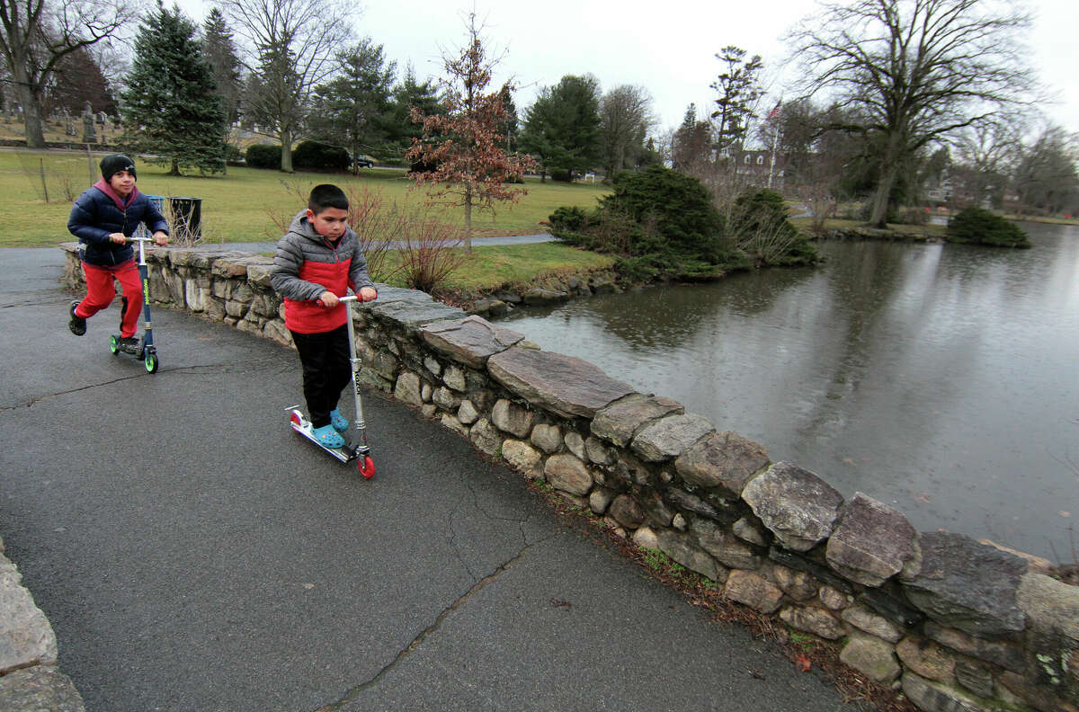 Daniel Duque, 7, and his cousin Jayden Castellano, 11, in back, ride their scooters at Binney Park in Greenwich, Conn., on Friday February 17, 2023.