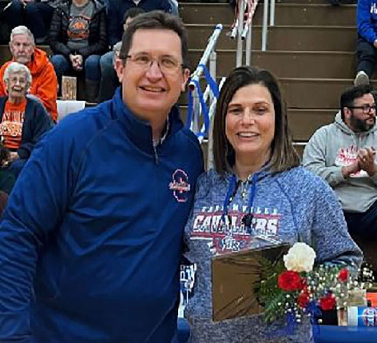Retiring Carlinville High teacher Mary Lauwerens (right) accepts a plaque from Cavaliers AD Darrin DeNeve honoring her service to the CHS basketball programs.