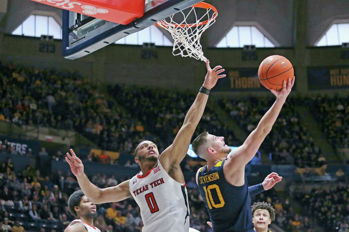West Virginia guard Erik Stevenson (10) shoots asTexas Tech forward Kevin Obanor (0) defends during the second half of an NCAA college basketball game on Saturday, Feb. 18, 2023, in Morgantown, W.Va.