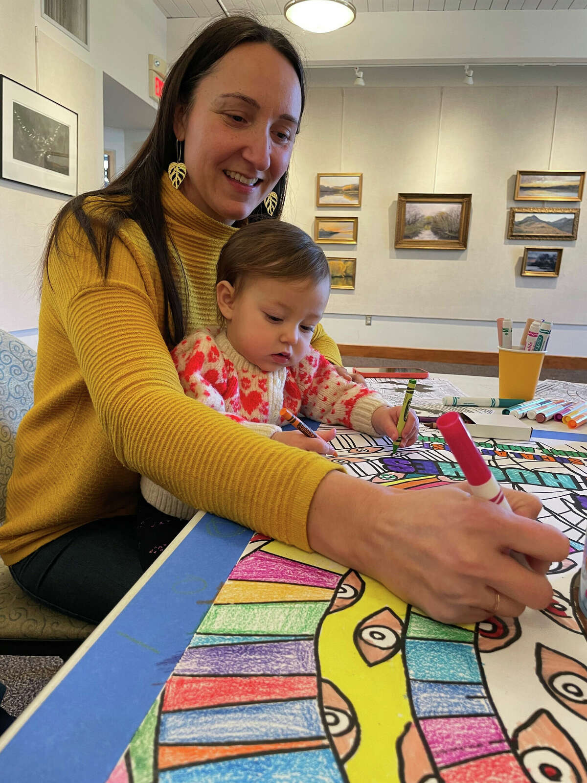 Sarah Cohen and her daughter, Ayla Noble, 14-months-old, color a portrait of Langston Hughes during The Great Americans Project event at the Willoughby Wallace Memorial Library.