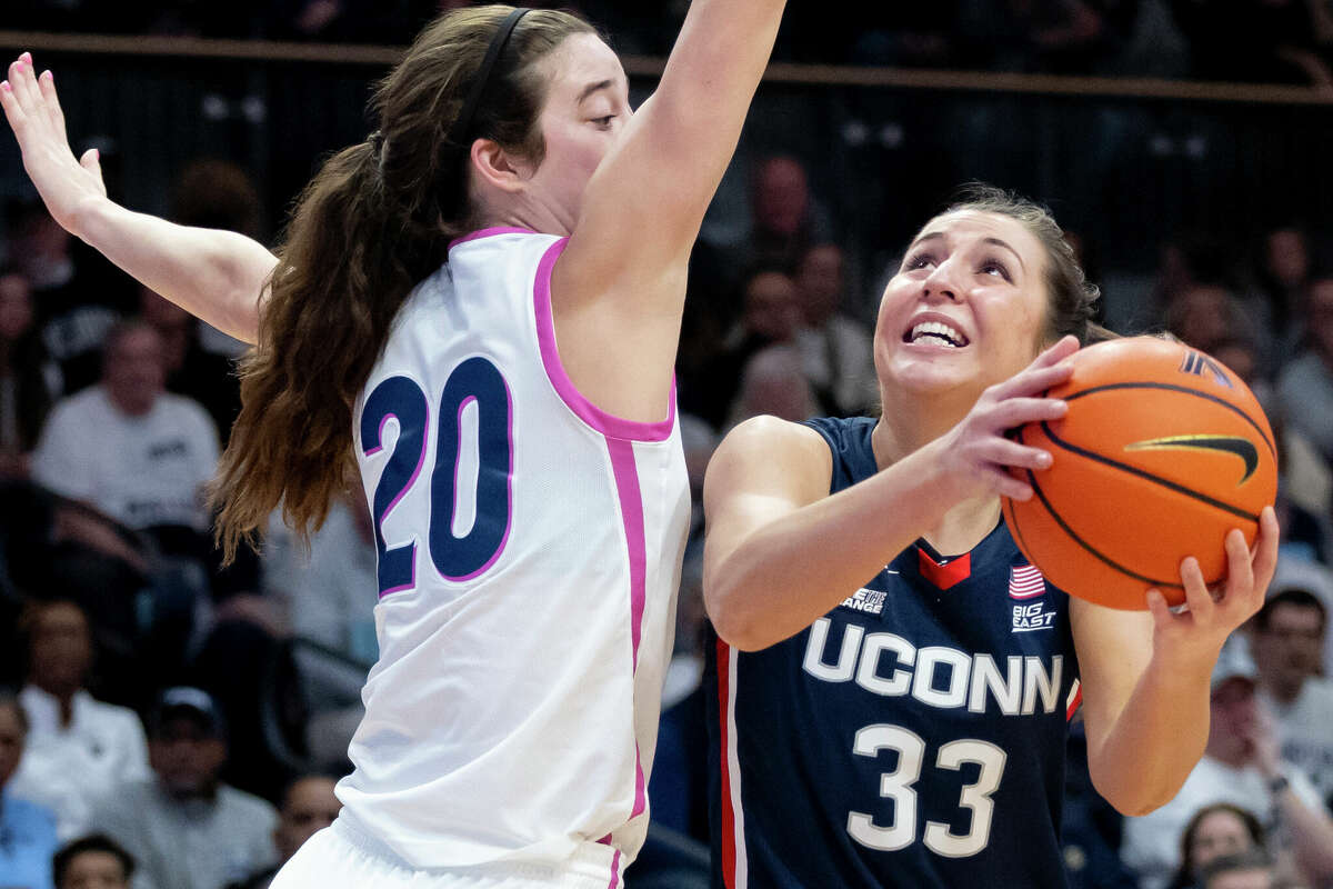 UConn guard Caroline Ducharme (33) goes to the basket past Villanova forward Maddy Siegrist (20) during the first half of an NCAA college basketball game, Saturday, Feb. 18, 2023, in Villanova, Pa. (AP Photo/Laurence Kesterson)