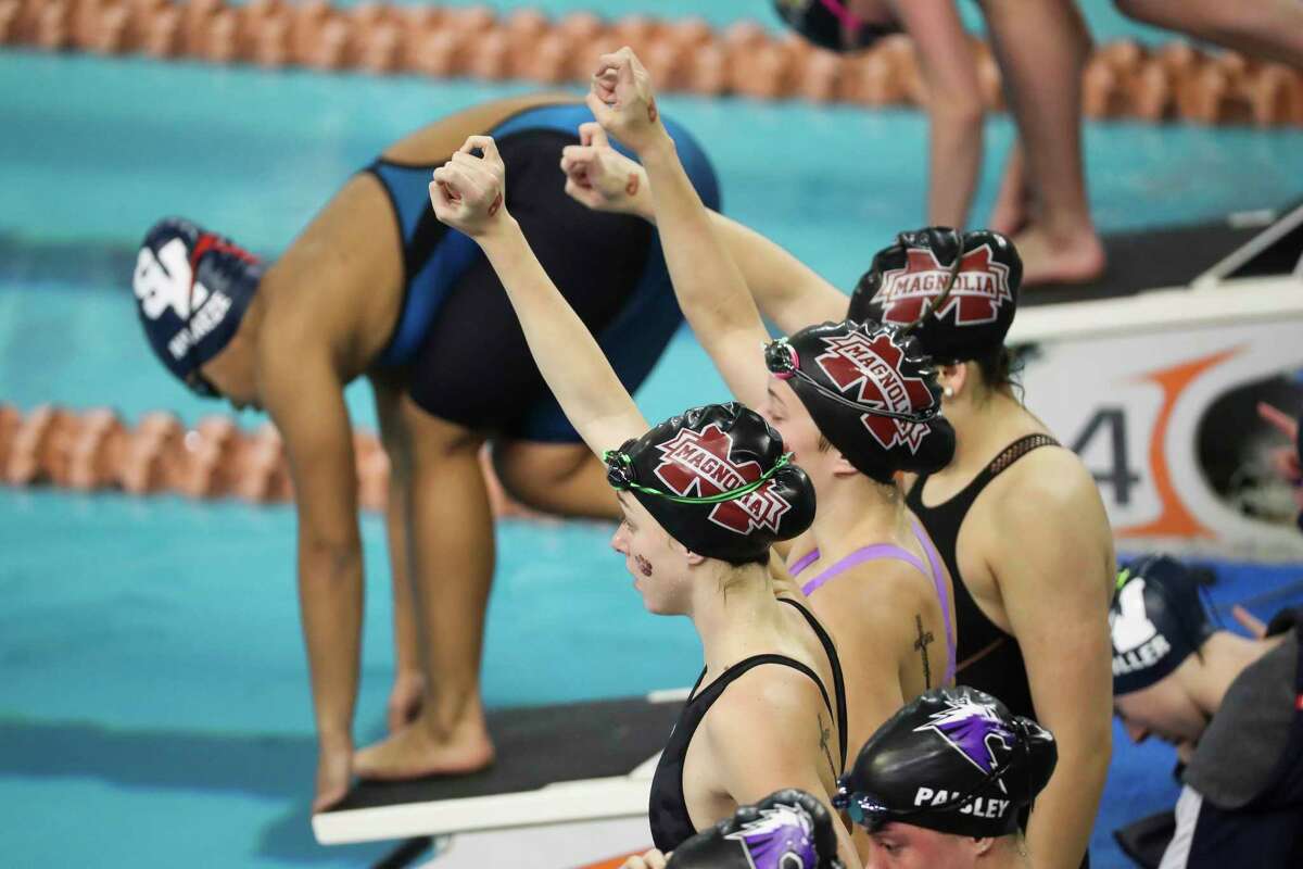 Magnolia swimmers hold up their hands before the start of the Class 5A girls 400-yard freestyle relay during the UIL State Swimming & Diving Championships, Saturday, Feb. 18, 2023, in Austin.