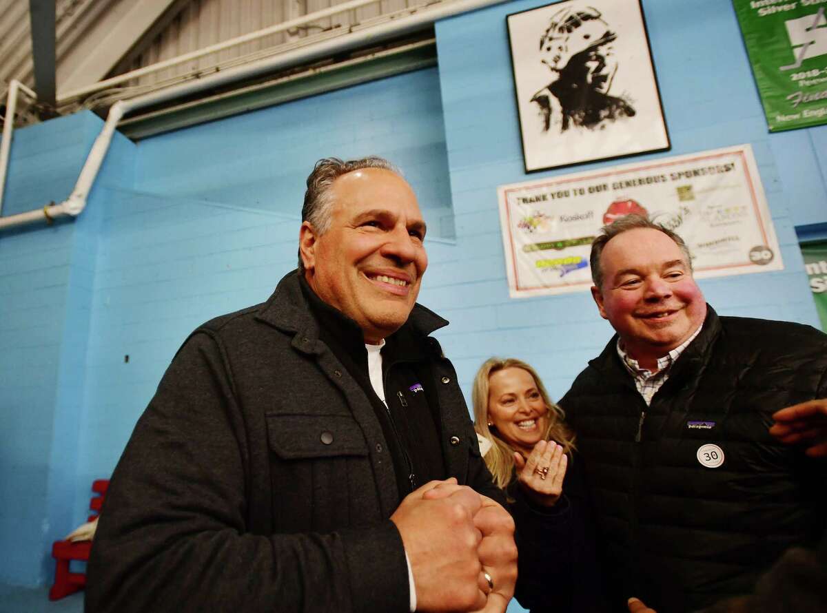 Anthony, left, and Jenny Capalbo, parents of deceased Fairfield hockey player Charlie Capalbo, unveil a portrait in their son's honor in a ceremony before the Fairfield/Greenwich hockey game at The Wonderland of Ice in Bridgeport, Conn. on Saturday, February 18, 2023. At right is rink Hockey Director John Ferguson.