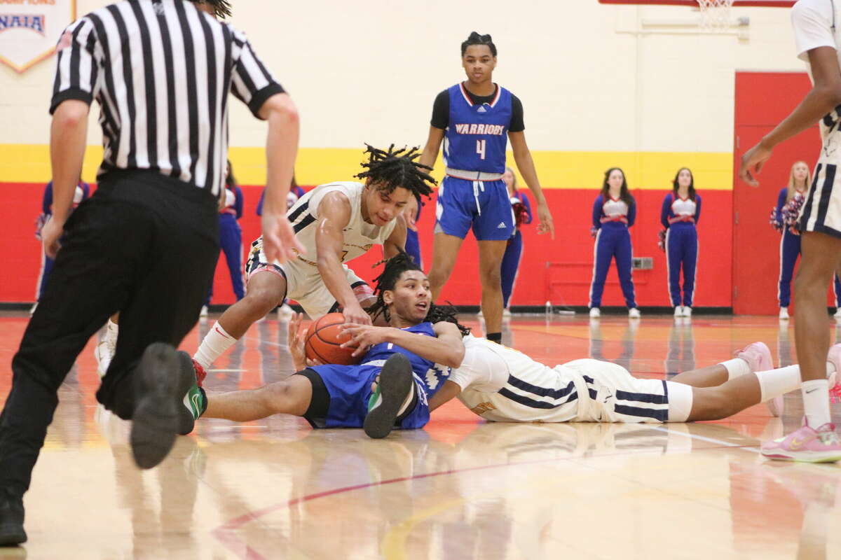 While on the St. Thomas University floor, Pasadena First Baptist's Donald Guillory does his best to keep the basketball out of the hands of Westbury Christian defenders.