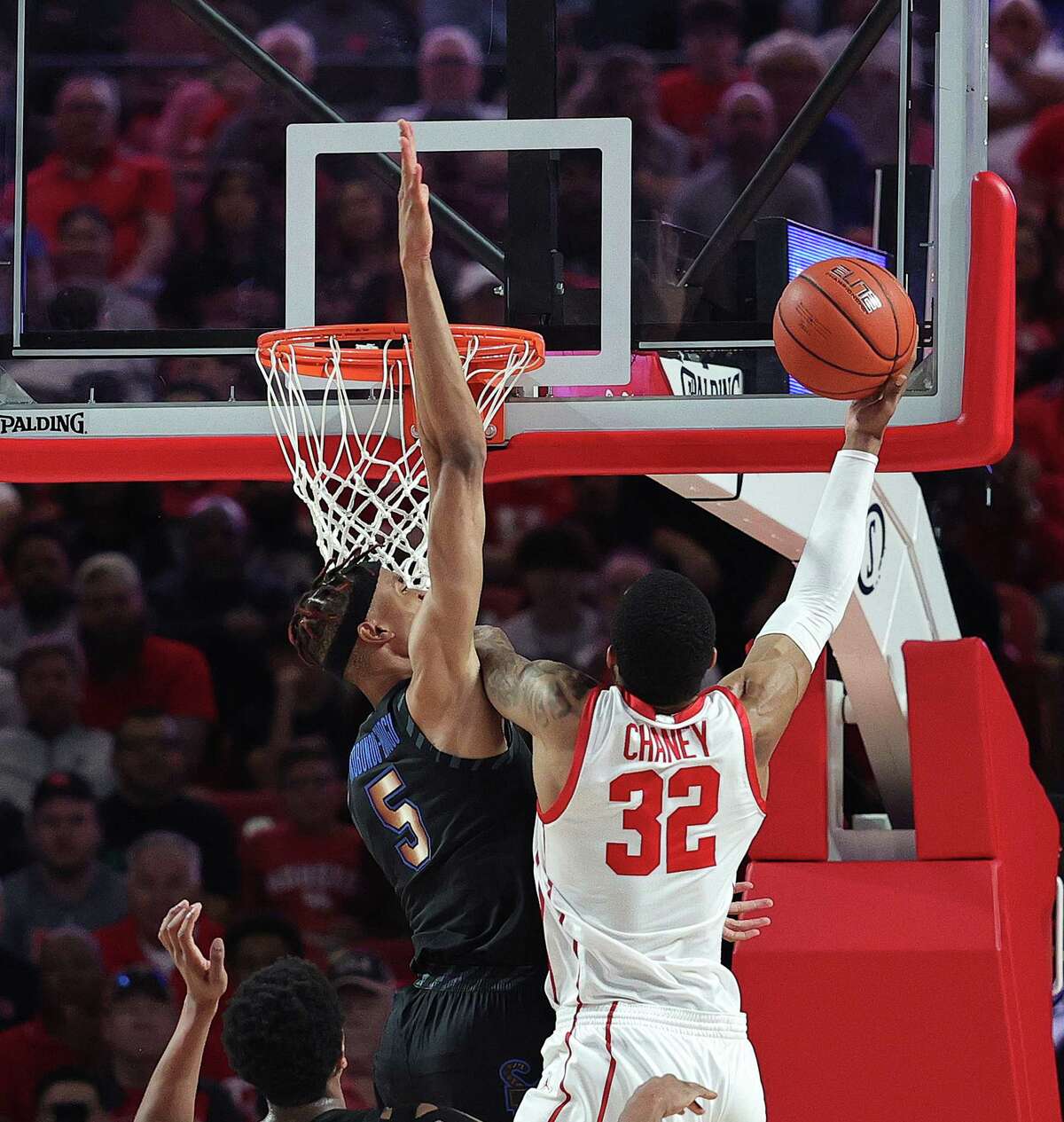 HOUSTON, TEXAS - FEBRUARY 19: Reggie Chaney #32 of the Houston Cougars drives to the basket on Kaodirichi Akobundu-Ehiogu #5 of the Memphis Tigers during the first half at Fertitta Center on February 19, 2023 in Houston, Texas.