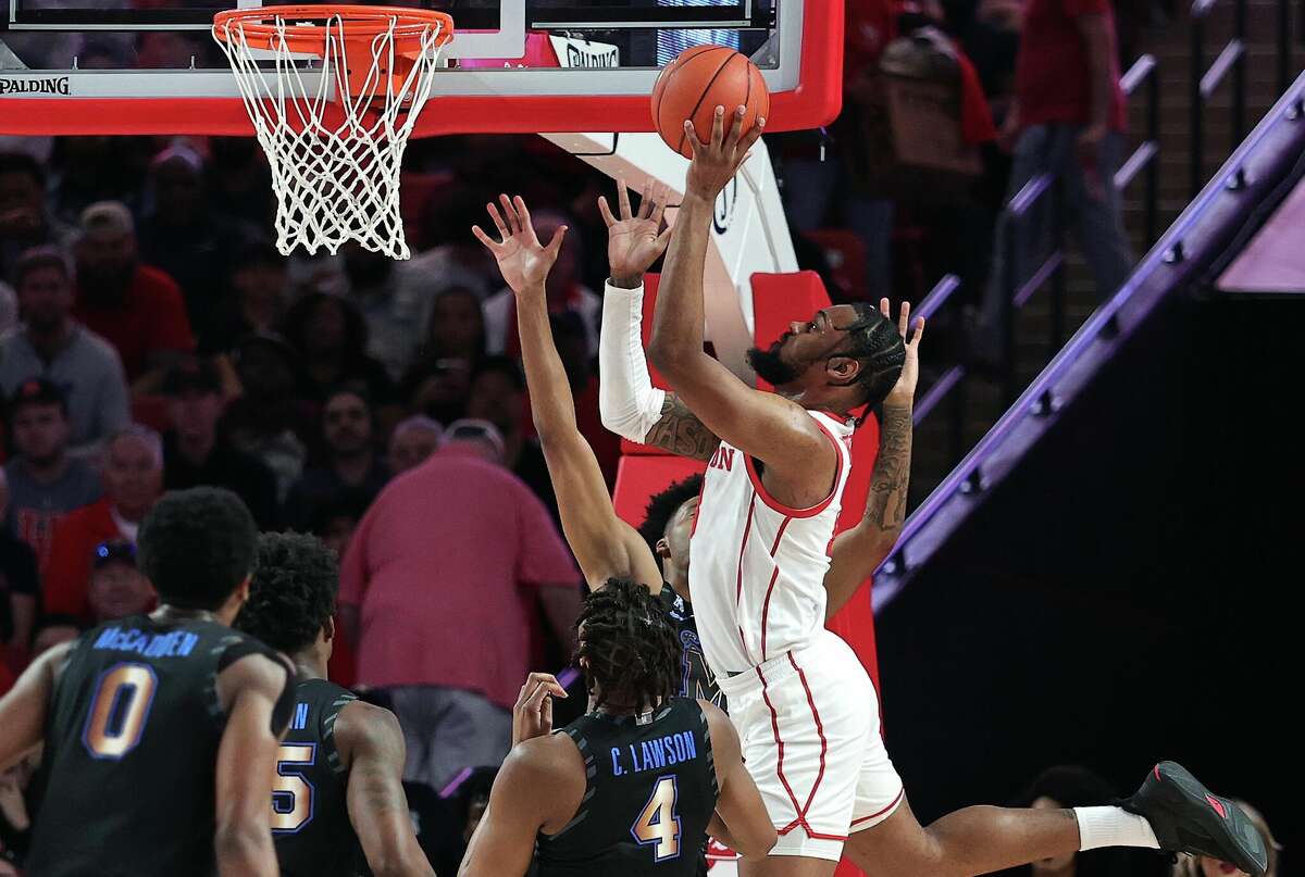 HOUSTON, TEXAS - FEBRUARY 19: J'Wan Roberts #13 of the Houston Cougars drives to the basket over Chandler Lawson #4 of the Memphis Tigers during the first half at Fertitta Center on February 19, 2023 in Houston, Texas. (Photo by Bob Levey/Getty Images)