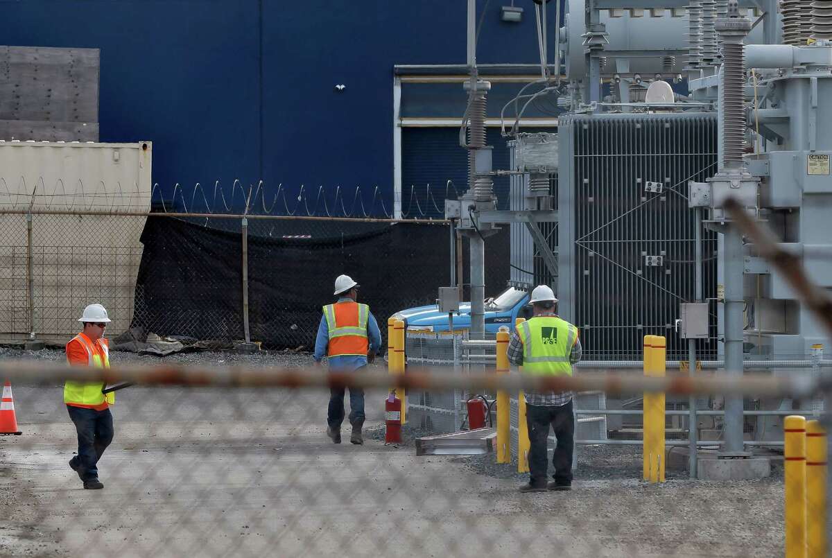 A PG&E crew works at the site of a substation on Coliseum Way where a fire earlier in the day caused a power failure.