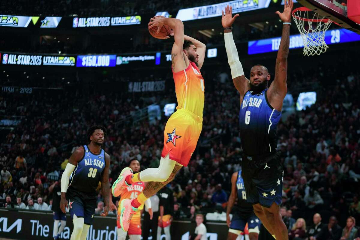 Team Giannis forward Jayson Tatum (0) dunks past Team LeBron forward LeBron James (6) during the first half of the NBA basketball All-Star game Sunday, Feb. 19, 2023, in Salt Lake City. (AP Photo/Rick Bowmer)