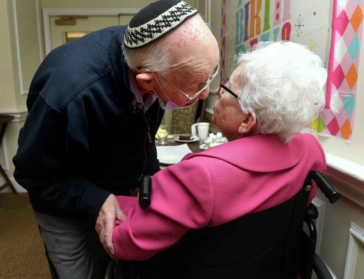 Goldie Taub, right, gets a kiss on her 100th birthday from her boyfriend, retired Rabbi Murray Levine, at Coachman Square at Woodbridge Monday in Woodbridge.