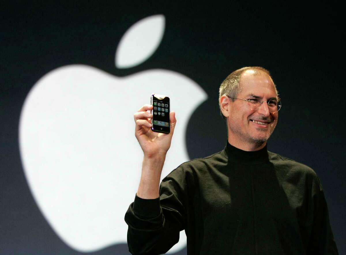 Apple CEO Steve Jobs holds up the new iPhone during his keynote address at MacWorld Conference & Expo in San Francisco on Jan. 9, 2007. Months later, it was at retail for the first time. 