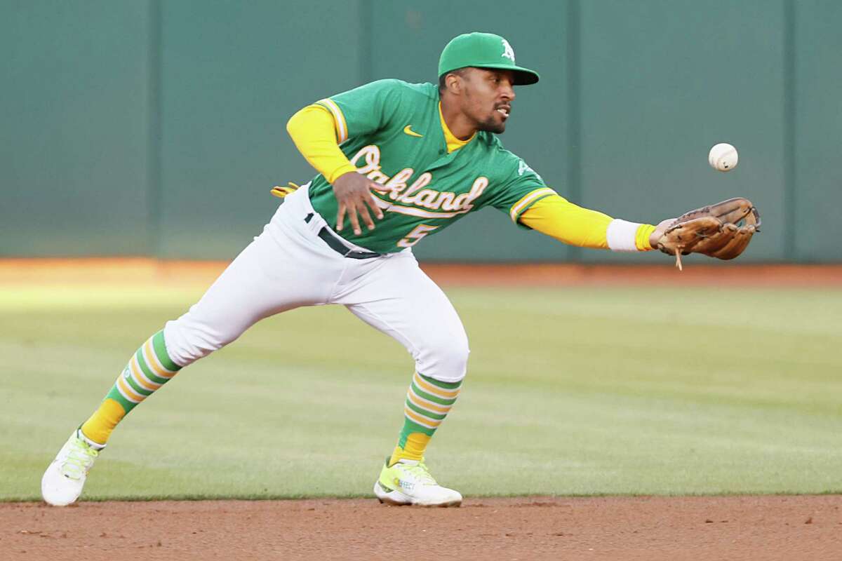 Oakland Athletics second baseman Tony Kemp (5) gains control of the loose ball and throws to first for an out in the 4th inning during an MLB game against the Texas Rangers at RingCentral Coliseum, Friday, July 22, 2022, in Oakland, Calif.