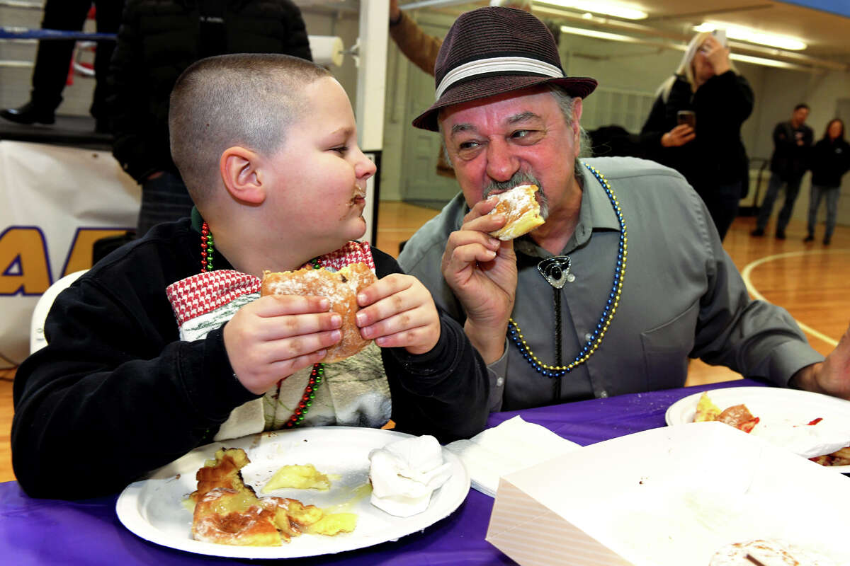 Joseph MacDowell, left, and his grandfather Joseph Cassetti take part in the annual Fat Tuesday Paczki Eating contest, in Ansonia, Conn. Feb. 21, 2023.