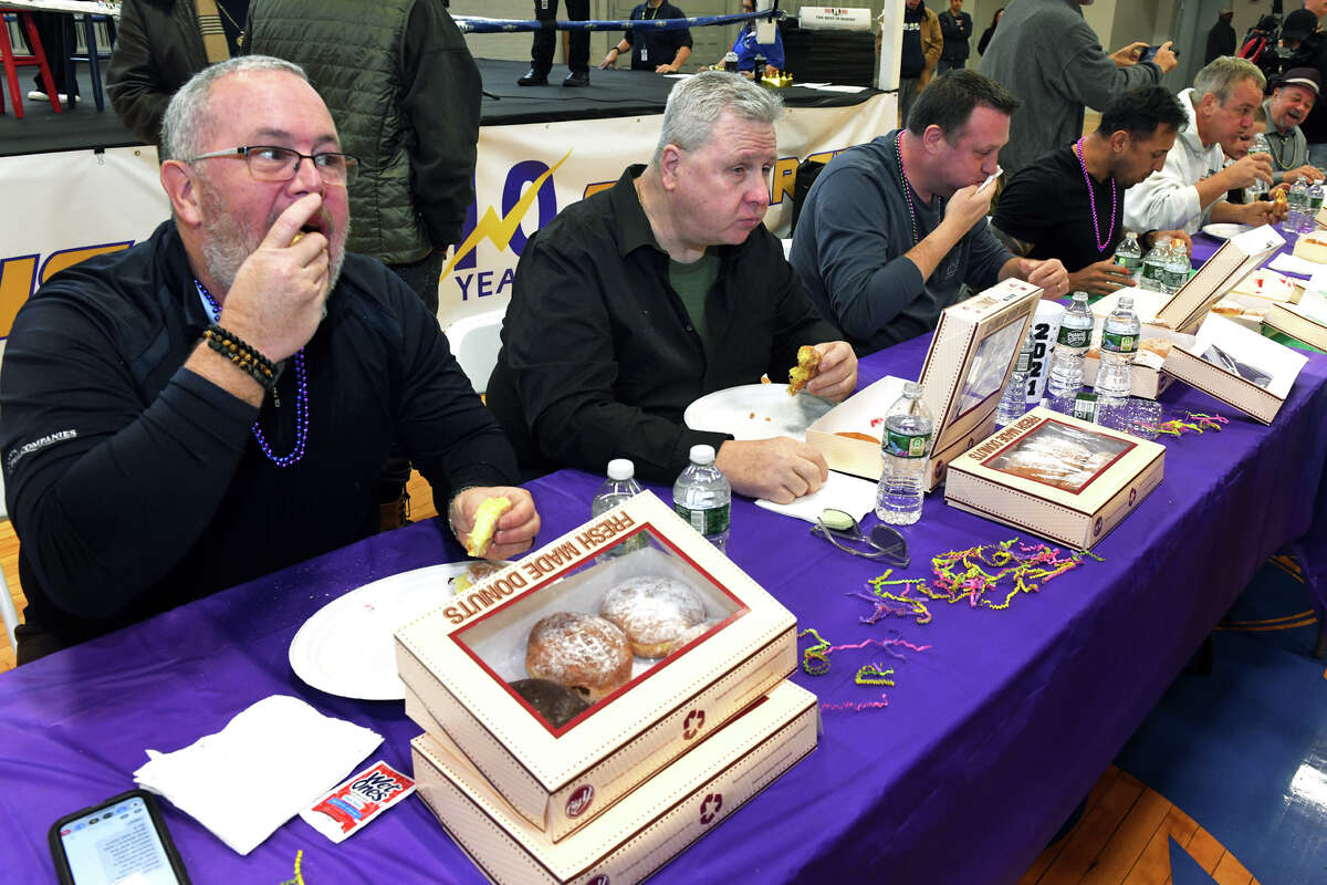 Kurt Miller, left, and others take part in the annual Fat Tuesday Paczki Eating contest, in Ansonia, Conn. Feb. 21, 2023.