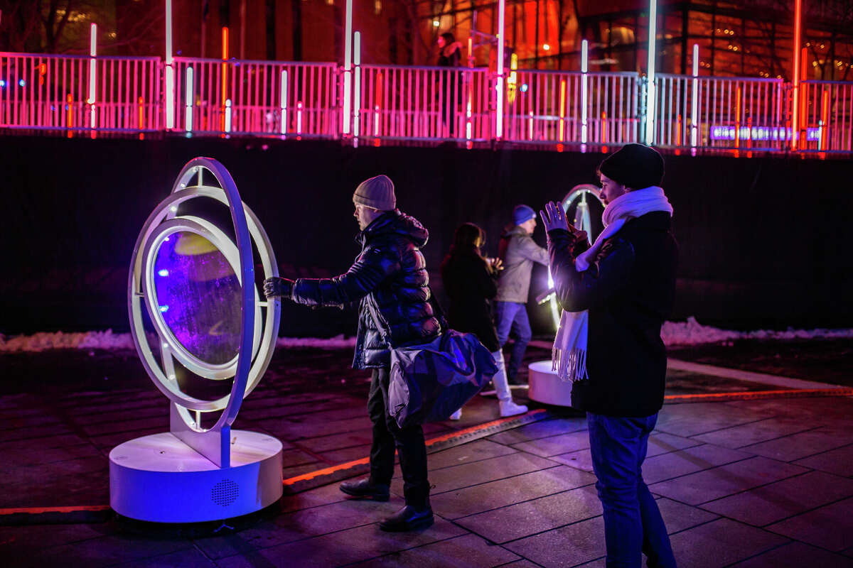 Visitors play with the interactive gyroscopic public art installation near the ice skating loop at Montreal en Lumiere. New, interactive public artworks are commissioned each year for the annual winter festival, (Frederique Menard Aubin)