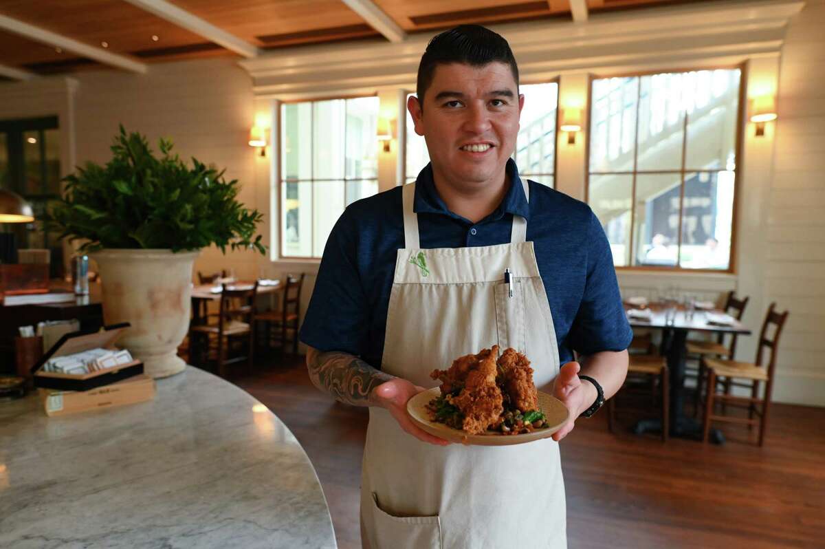 Jaime Gonzalez, executive chef at Carriqui, holds the smoked crispy quail dish.