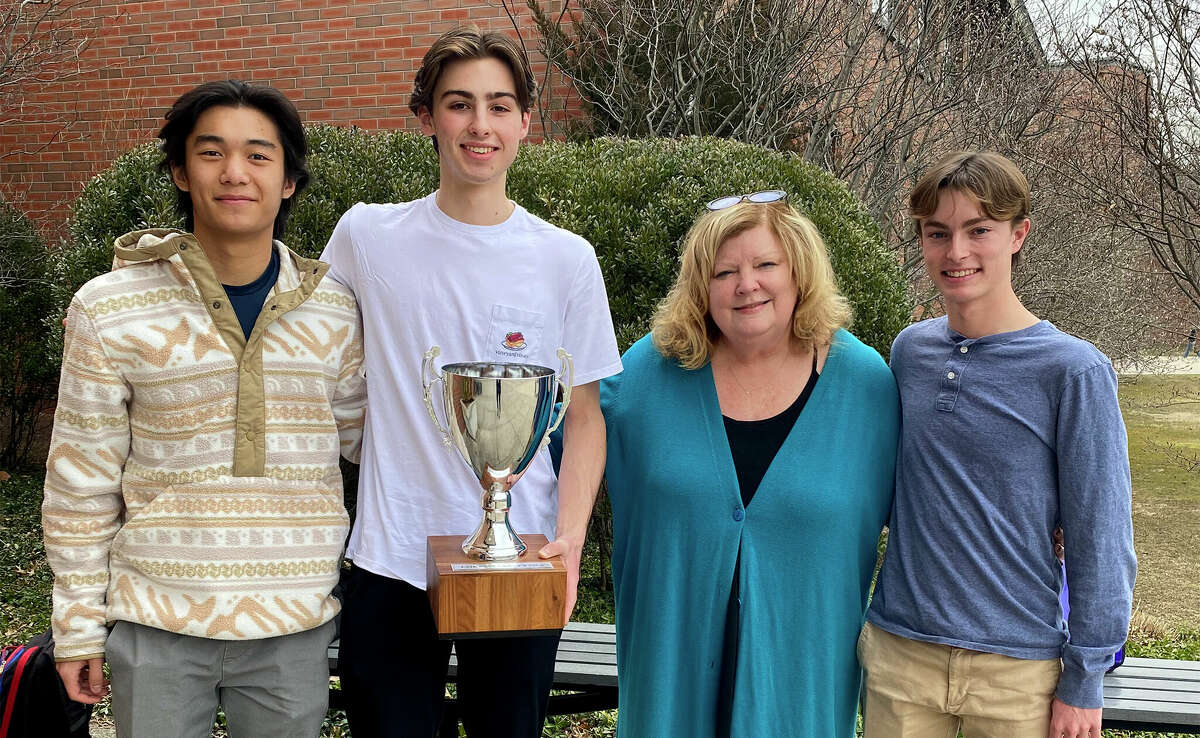Darien boys squash captains present the FairWest Cup to Principal Ellen Dunn. From left are David Zhao, Will Koons, Principal Dunn, and Andrew Banks.