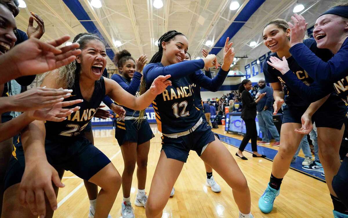 Cypress Ranch’s Alexis Duhon (12) celebrates the team's win over Tomball Memorial with teammates in a Region II-6A quarterfinal high school basketball playoff game, Tuesday, Feb. 21, 2023, in Houston.