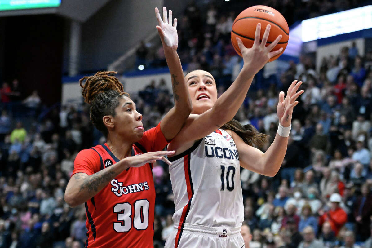 UConn's Nika Muhl (10) goes up to the basket as St. John's Kadaja Bailey (30) defends in the first half of an NCAA college basketball game, Tuesday, Feb. 21, 2023, in Hartford, Conn. (AP Photo/Jessica Hill)