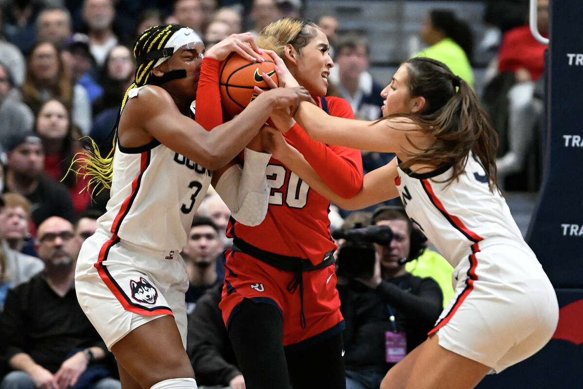 UConn's Aaliyah Edwards, left, and Caroline Ducharme, right, pressure St. John's Rayven Peeples, center, in the first half of an NCAA college basketball game, Tuesday, Feb. 21, 2023, in Hartford, Conn. (AP Photo/Jessica Hill)