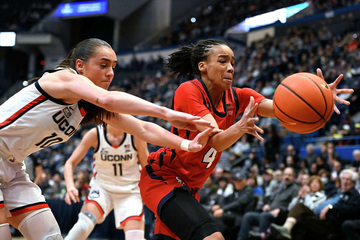 UConn's Nika Muhl (10) and St. John's Jayla Everett (4) reach for a loose ball in the first half of an NCAA college basketball game, Tuesday, Feb. 21, 2023, in Hartford, Conn. (AP Photo/Jessica Hill)