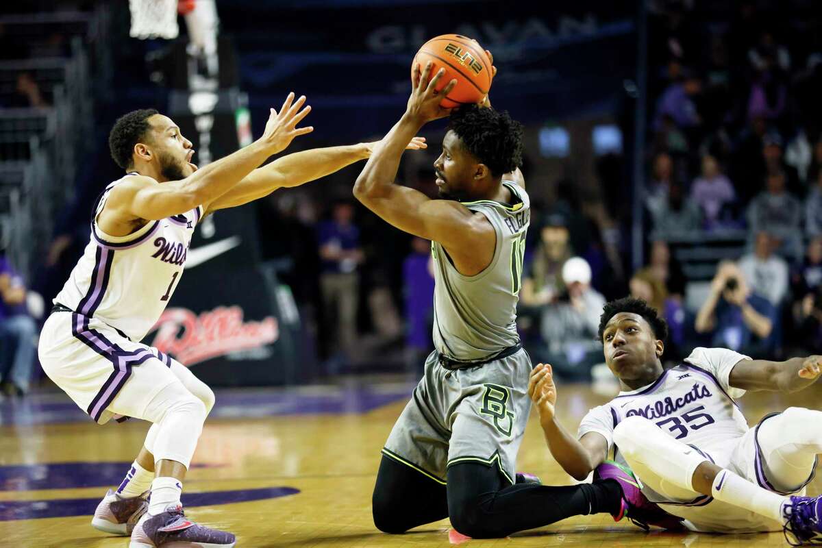 Baylor guard Adam Flagler (10) attempts to pass after grabbing a loose ball as Kansas State's Markquis Nowell (1) and Nae'Qwan Tomlin (35) defend during the first half of an NCAA college basketball game, Tuesday, Feb. 21, 2023, in Manhattan, Kan.