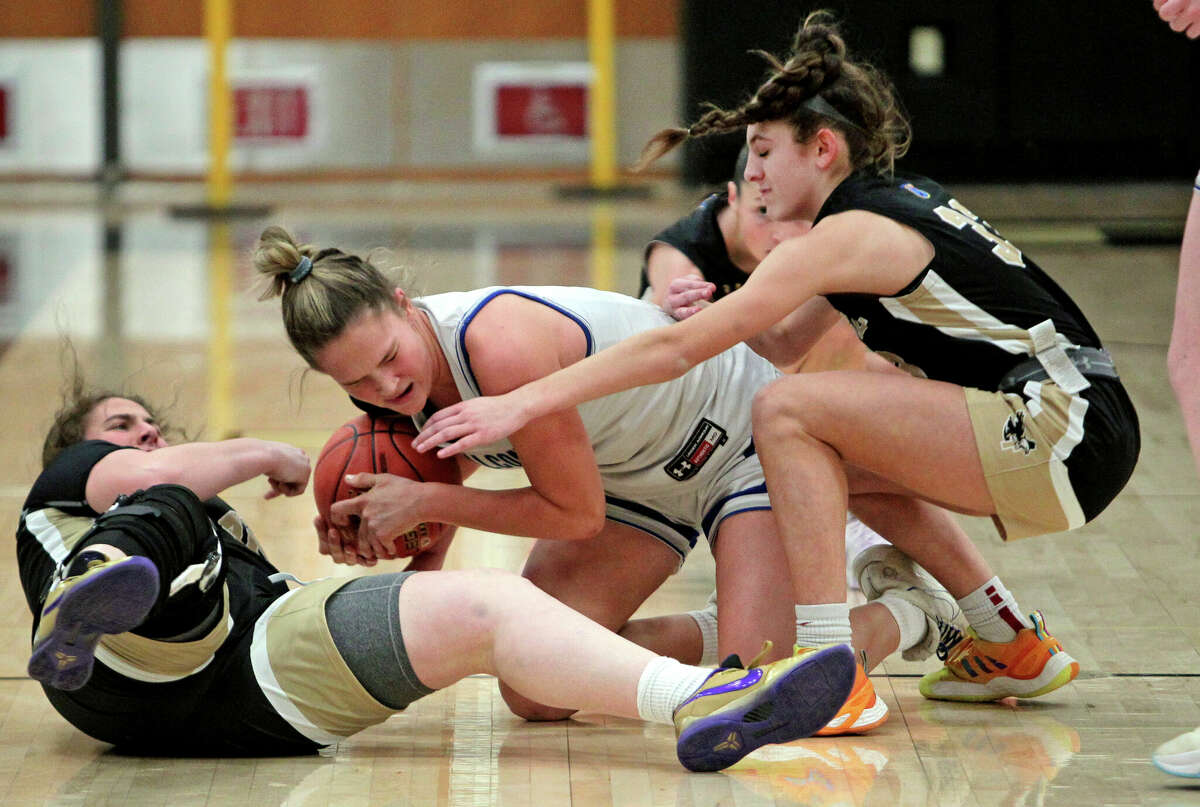 Fairfield Ludlowe's Kaleigh Sommers, center, tries to hang onto the ball as Trumbull's Michaela Diamond (33), at right, converges during FCIAC girls basketball semifinals action in Trumbull, Conn., on Tuesday February 21, 2023.