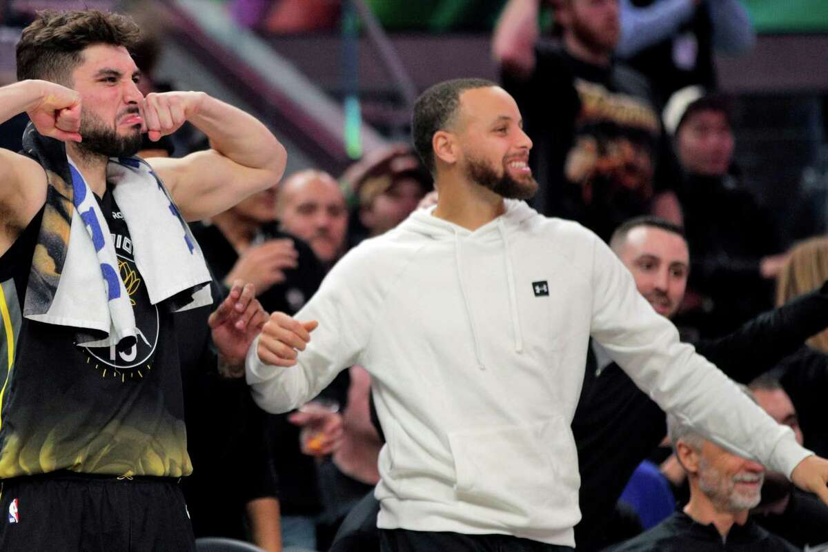 Stephen Curry (30) cheers with Ty Jerome (10) as he watches the action during the Golden State Warriors game against the Washington Wizards at Chase Center in San Francisco, Calif., on Monday, February 13, 2023.