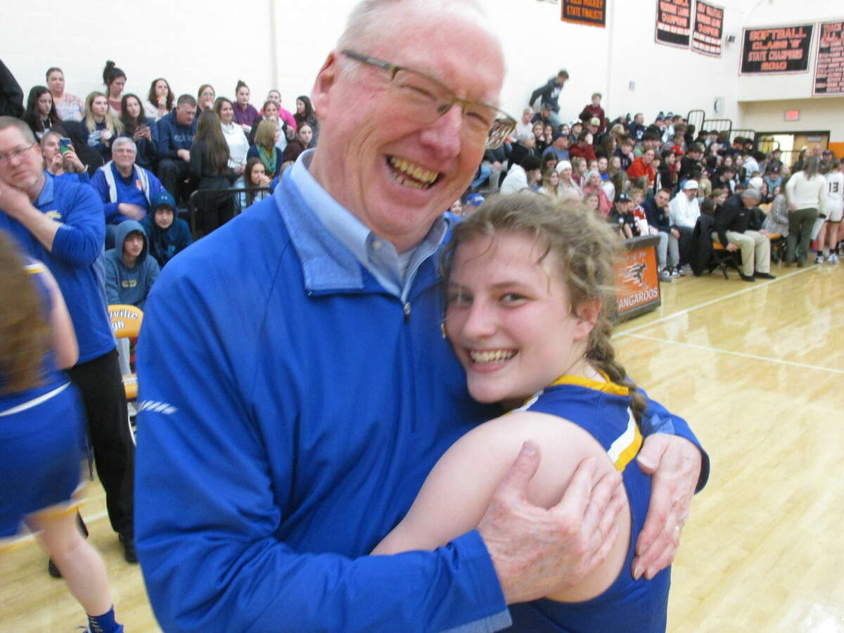 Gilbert Coach Gerry Hicks and sophomore Emily Arel celebrate Arel's 1,000th career point in an overtime loss to Thomaston in a Berkshire League Girls Basketball Tournament semifinal game at Terryville High School Tuesday night. 
