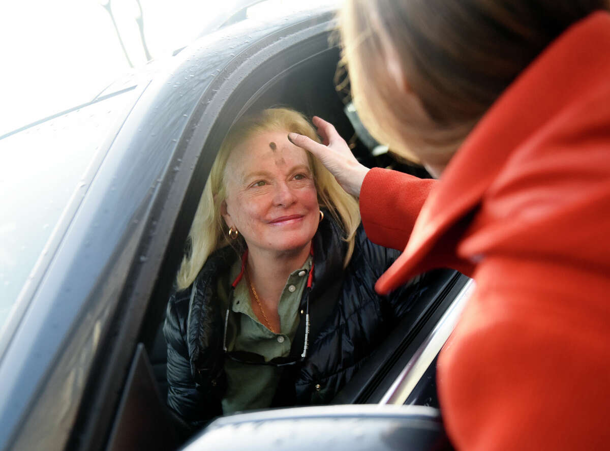 Barbara Buffone receives ashes from Jenny Byxbee, Minister of Care and Connection, during the drive-thru ash service at Second Congregational Church in Greenwich, Conn. Wednesday, Feb. 22, 2023. The church offered a drive-thru ash service for its congregants to mark Ash Wednesday, the start of Lent.