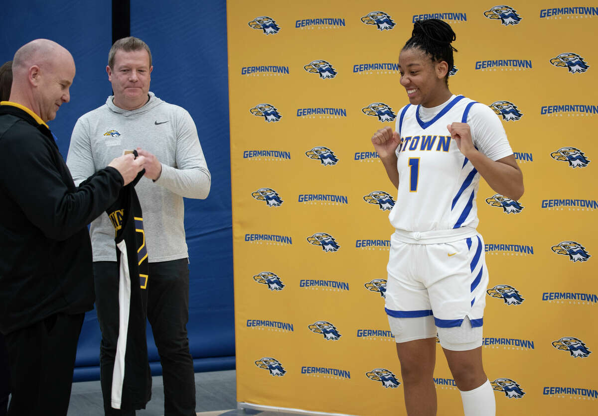 Coach Matt Stuve presents KK Arnold with her McDonald's All-American jersey as a surprise before her team's game at Germantown High School in Germantown, Wisconsin Tuesday, Feb. 14, 2023.