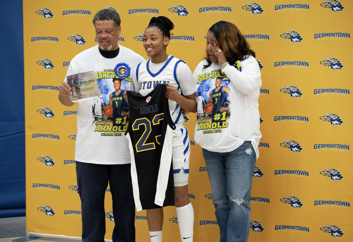 UConn recruit KK Arnold poses with her parents Mike and Kim ahead of Arnold's game at Germantown High School in Germantown, Wisconsin Tuesday, Feb. 14, 2023.