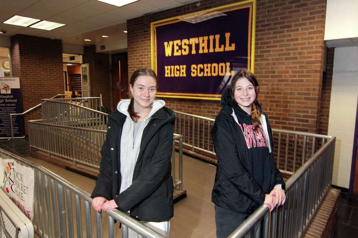 Westhill High School students Jackie Brzoska, left, and Lilly Lapine pose together at the school in Stamford, Conn., on Tuesday February 21, 2023. Brzoska and Lapine are two Westhill students who had lined up internships for their senior year. But, back in October, they found out that the district had changed the structure of the internship program, which made it impossible for them to do their original plan.